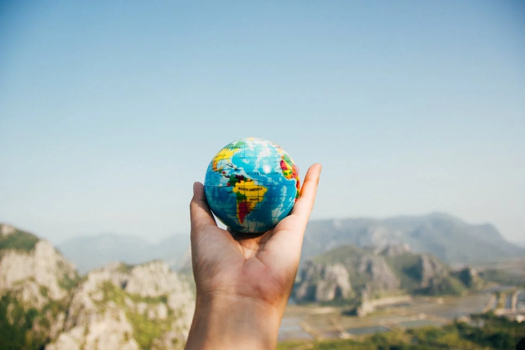 Hand Holding A Small Earth Globe
