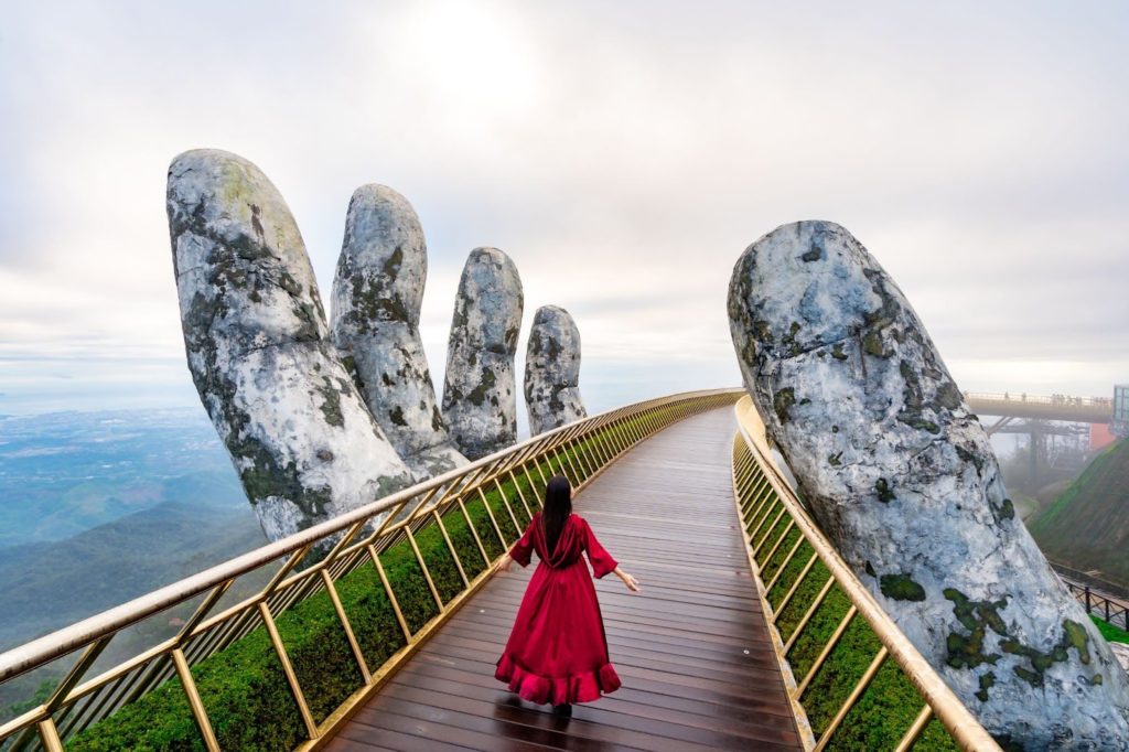female tourist walking on the golden bridge at vietnam