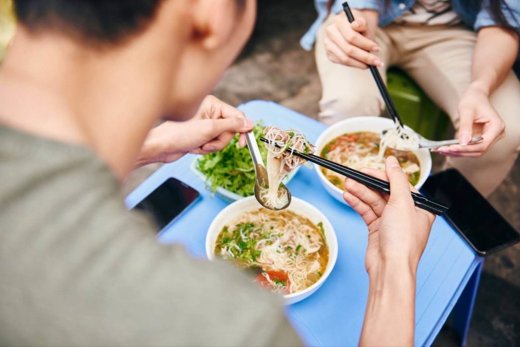 people sitting eating pho